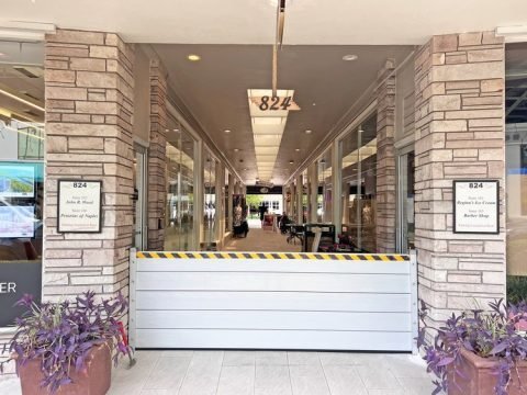 Custom aluminum flood barrier sealing a commercial glass entry to prevent flooding in Miami