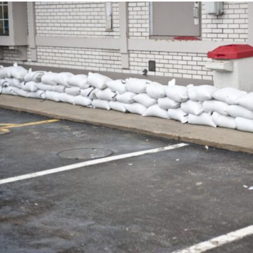 Sandbags stacked outside a commercial building for emergency flood control and water diversion